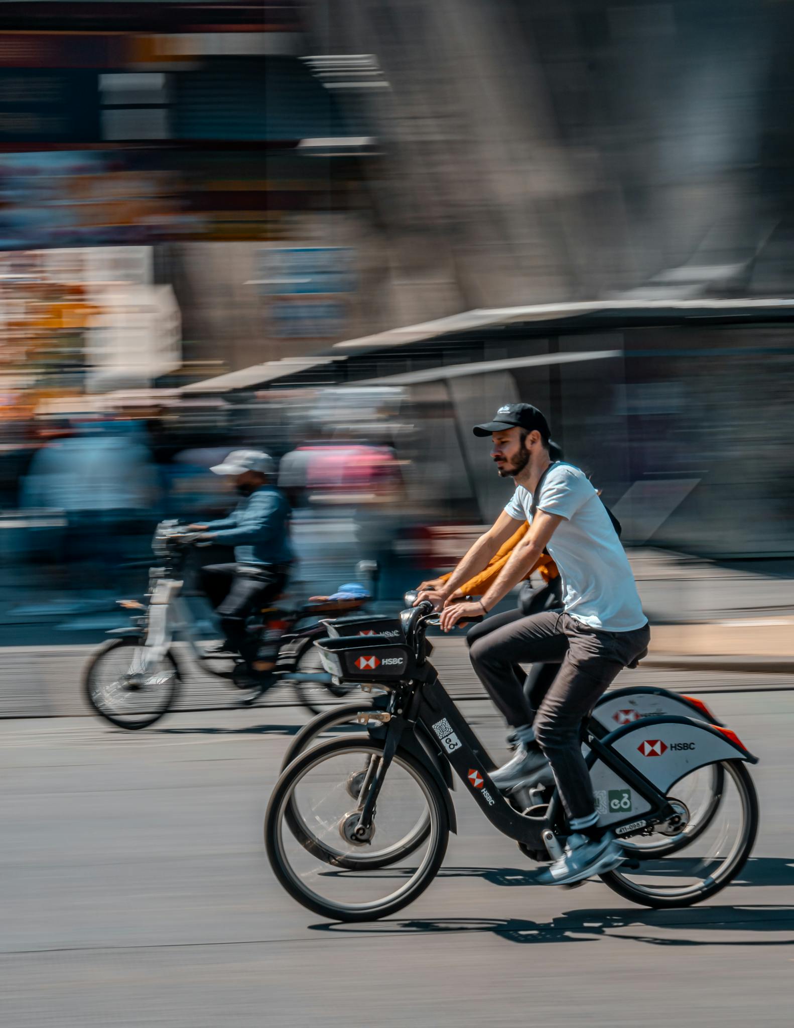 A man riding a bicycle through a bustling city street, capturing motion and urban life.